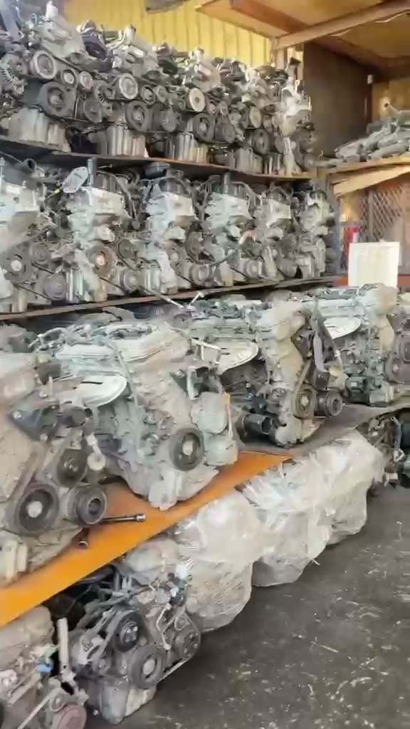 Used engines on shelves, some wrapped in plastic on the bottom row
